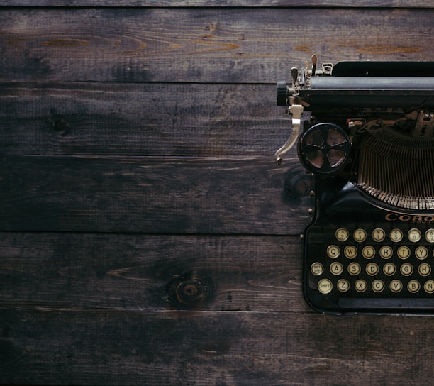 black Corona typewriter on brown wood planks