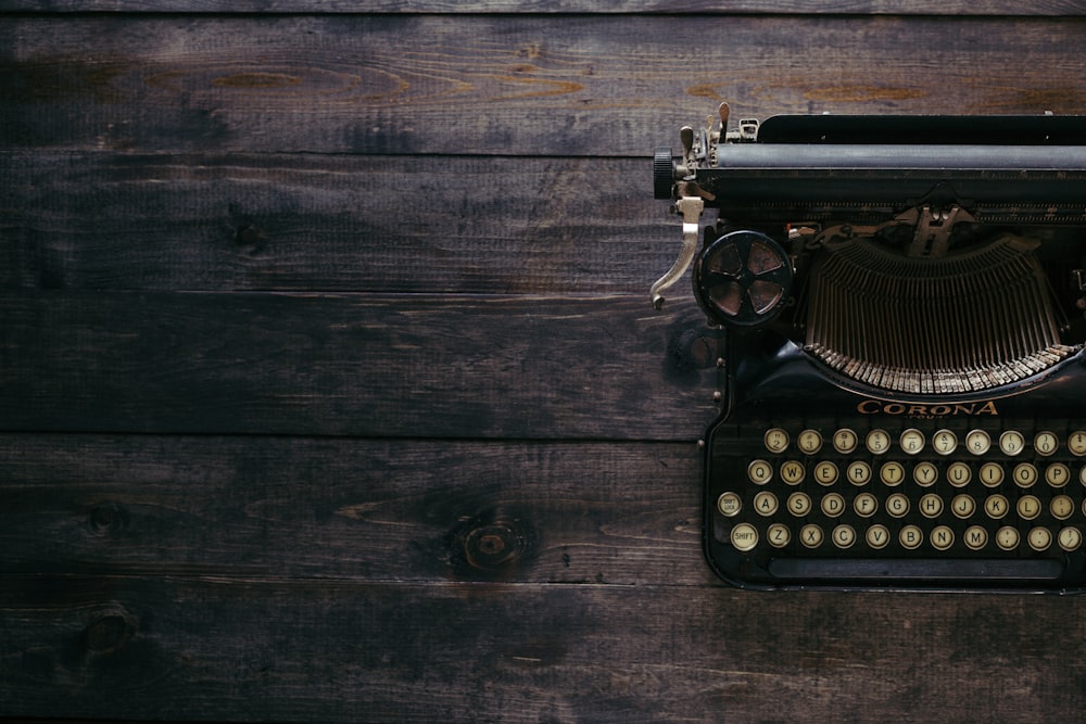 black Corona typewriter on brown wood planks