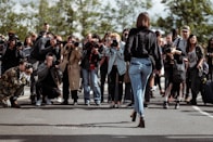woman walking taking photo by people