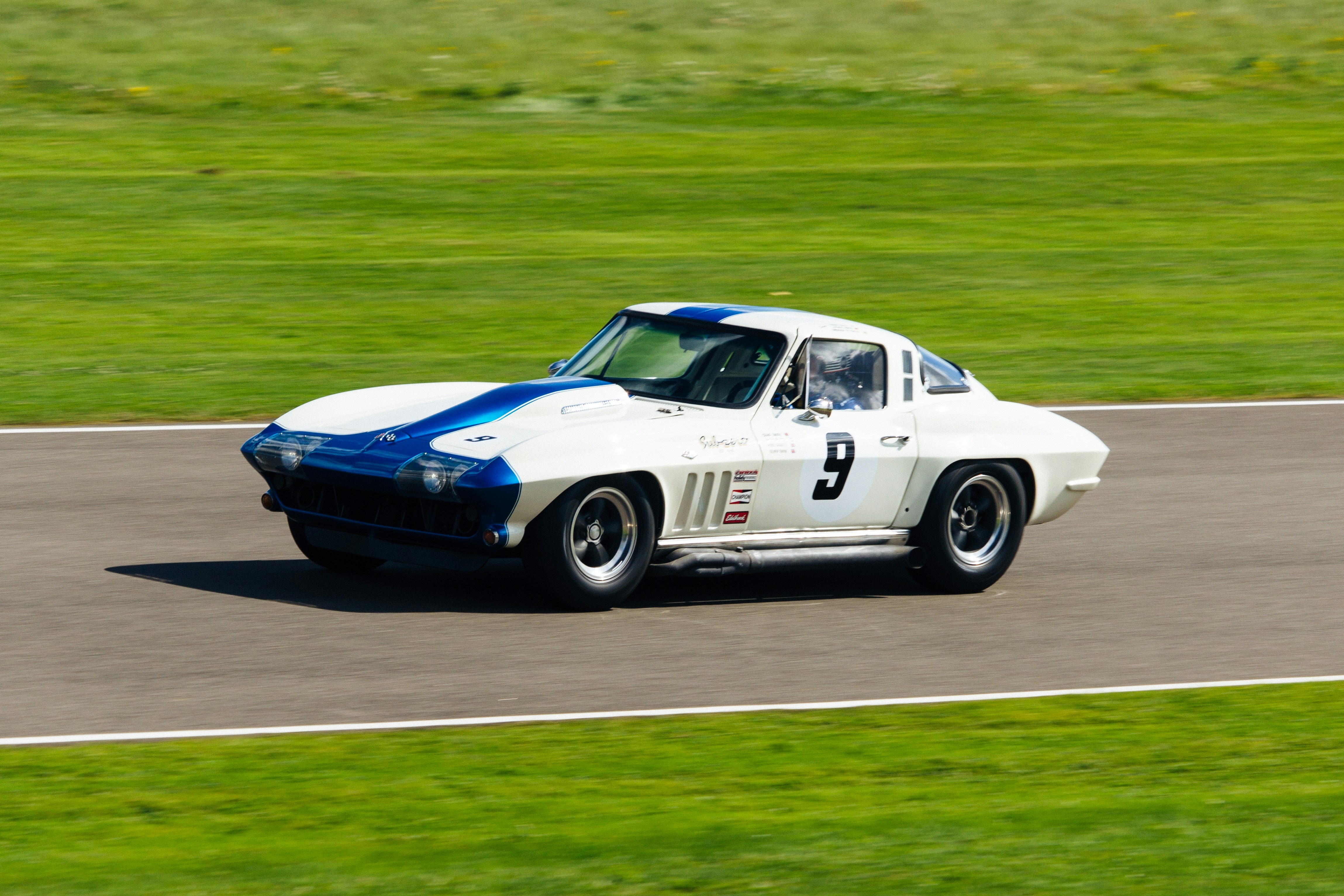 photo of white and blue coupe on grey concrete road