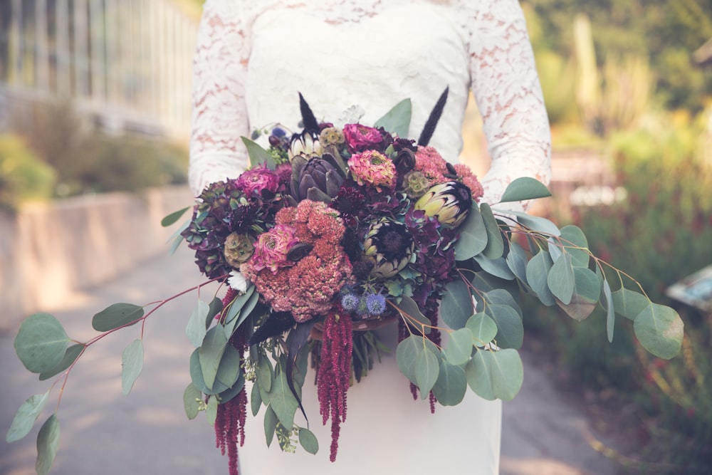 landscape photography of woman holding assorted-color flowers