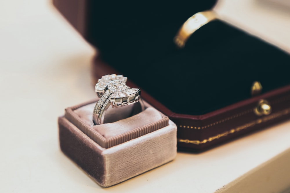 silver-colored clear gemstone ring with box