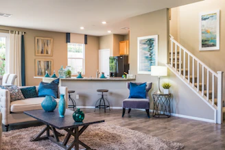 A living room with a sofa, coffee table, and open kitchen area