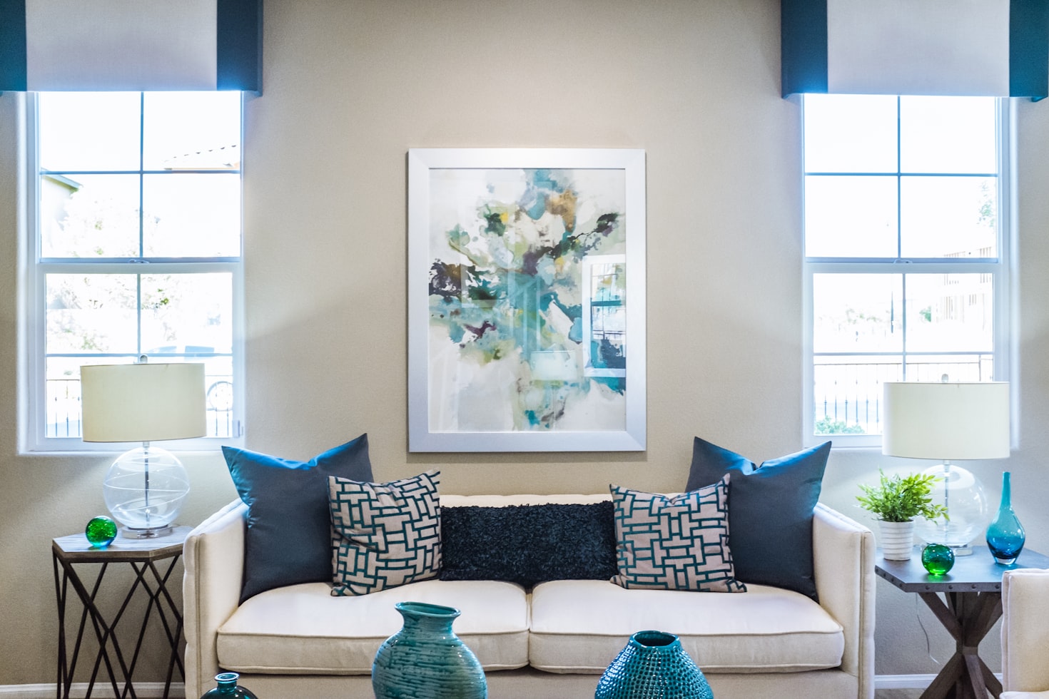 A beige sofa with blue throw pillows placed against a wall