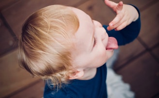 child dancing on brown wooden floor close-up photo