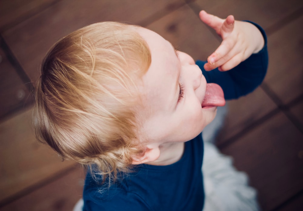 child dancing on brown wooden floor close-up photo