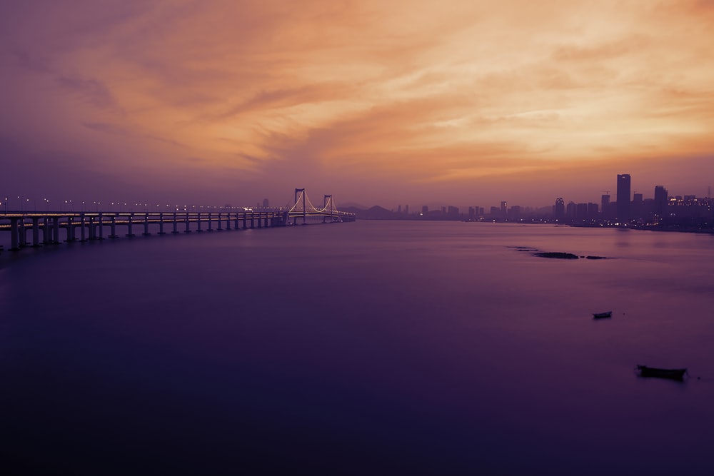 ゴールデンアワーの写真撮影中の水域の上の灰色の橋