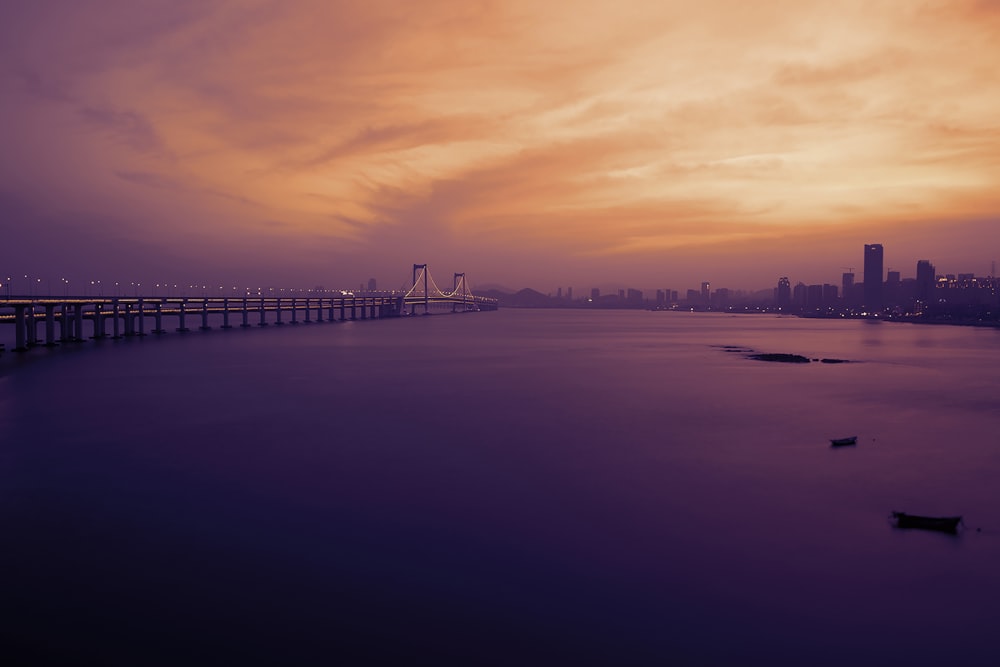 gray bridge above body of water during golden hour photography