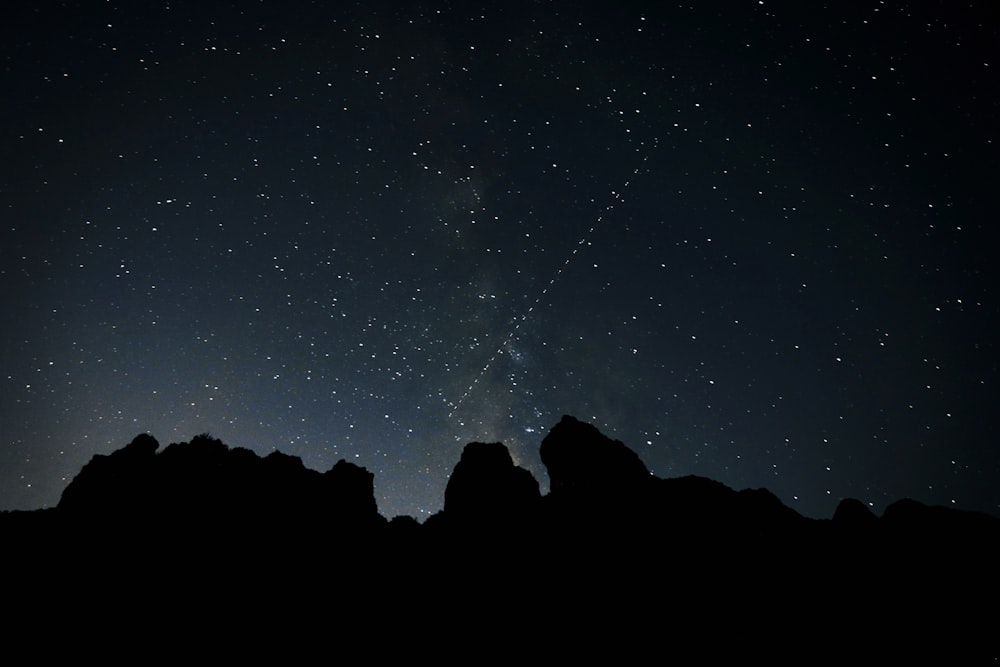 silhouette of mountain under milky way