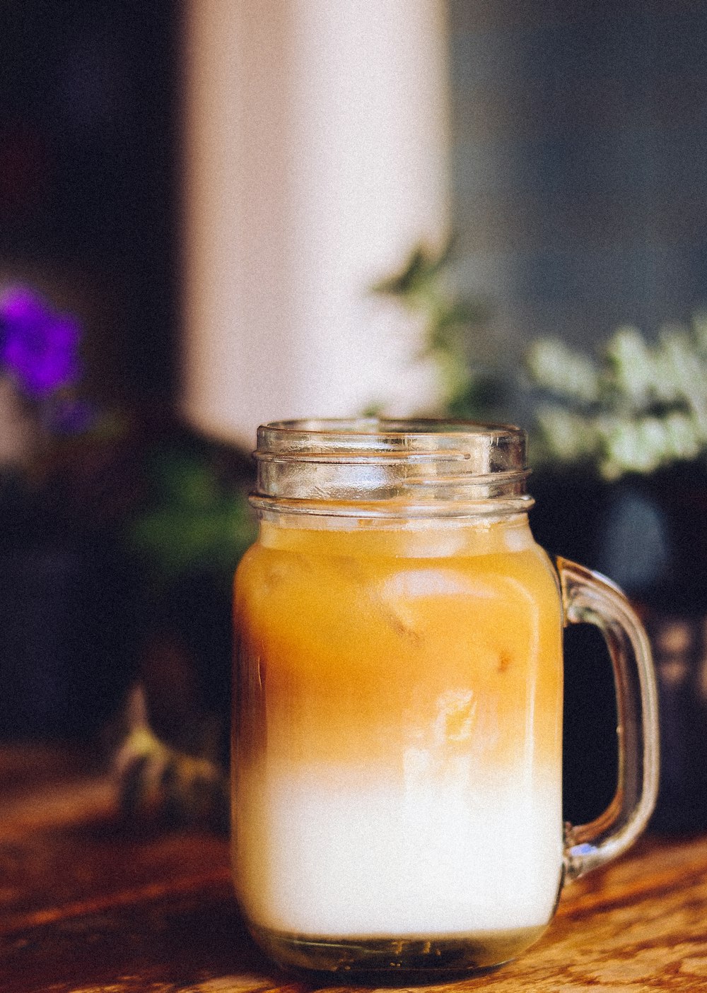 clear glass mason mug full of orange and white liquid