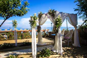 A beautifully decorated wedding arch with flowing fabrics and natural flowers in soft pastel tones.