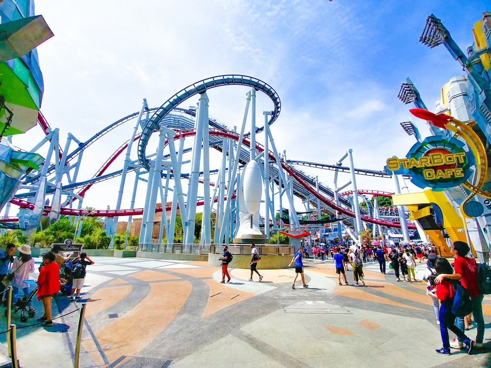 Gente del parque de atracciones bajo el cielo azul claro durante el día