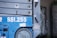 A close-up view of industrial machinery with a prominent blue color, featuring the number SSI.255 in large white text. Visible are several metallic components, including a wheel and bolts, with some wear and rust.