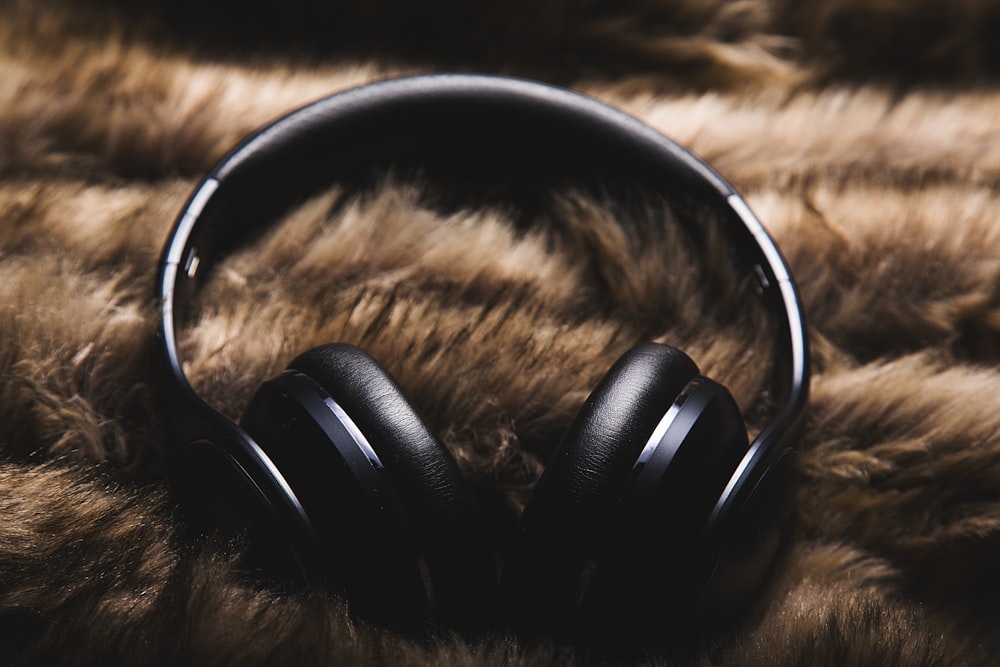 black headphones on brown textile