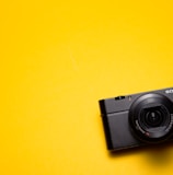 black Sony point-and-shoot camera on yellow surface