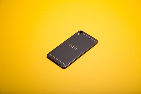 A sleek modern smartphone displayed on a dark background with yellow accents