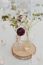 white flower arrangement on glass bottle on tabletop