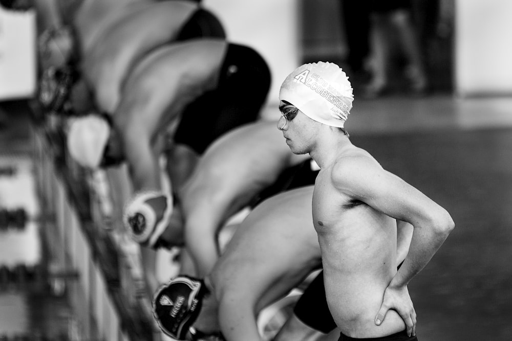 grayscale photo of swimmers about to dive