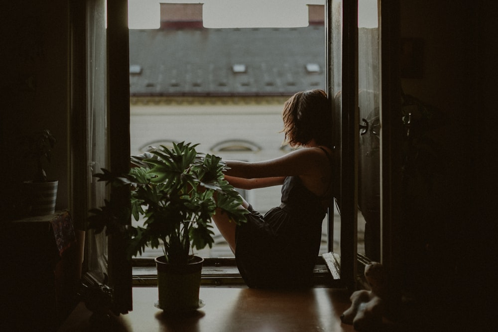 woman leaning on door looking outside