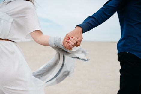 man and woman holding hands together in field during daytime