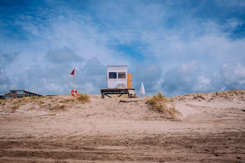 white lifeguard shed beside flag during daytime