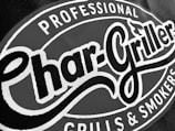 A close-up of a logo with the words 'Char-Griller' in bold, stylized font encircled by the phrases 'Professional Grills & Smokers'.