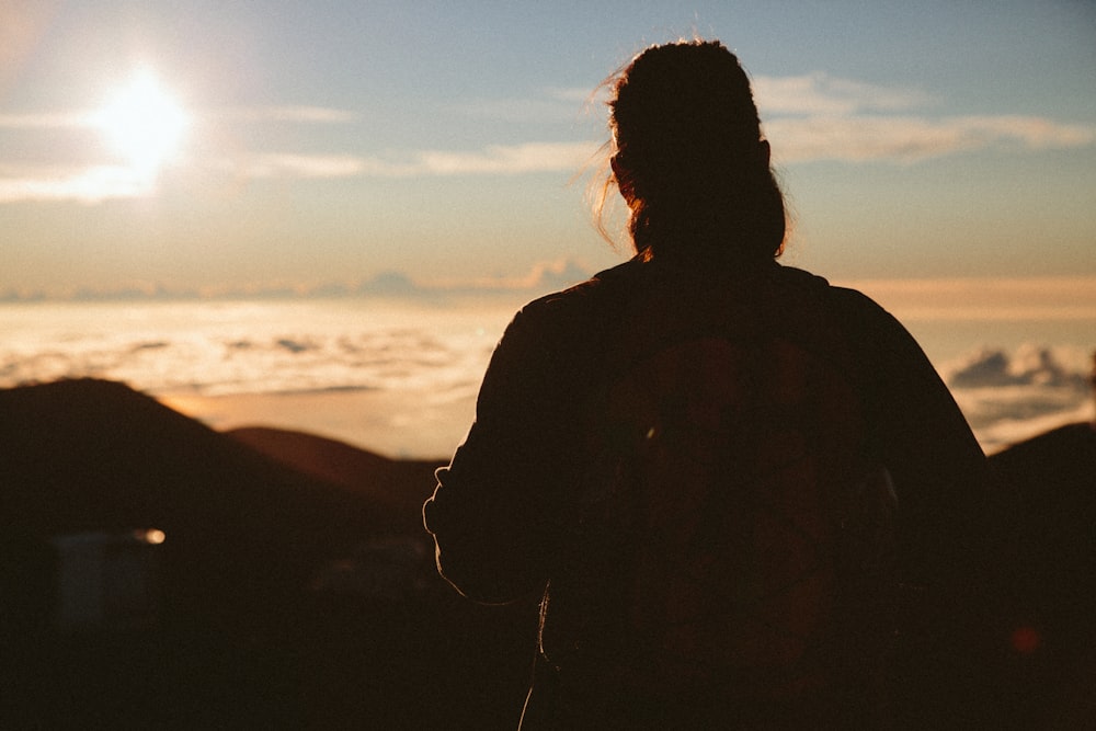 silhouette of woman facing hills