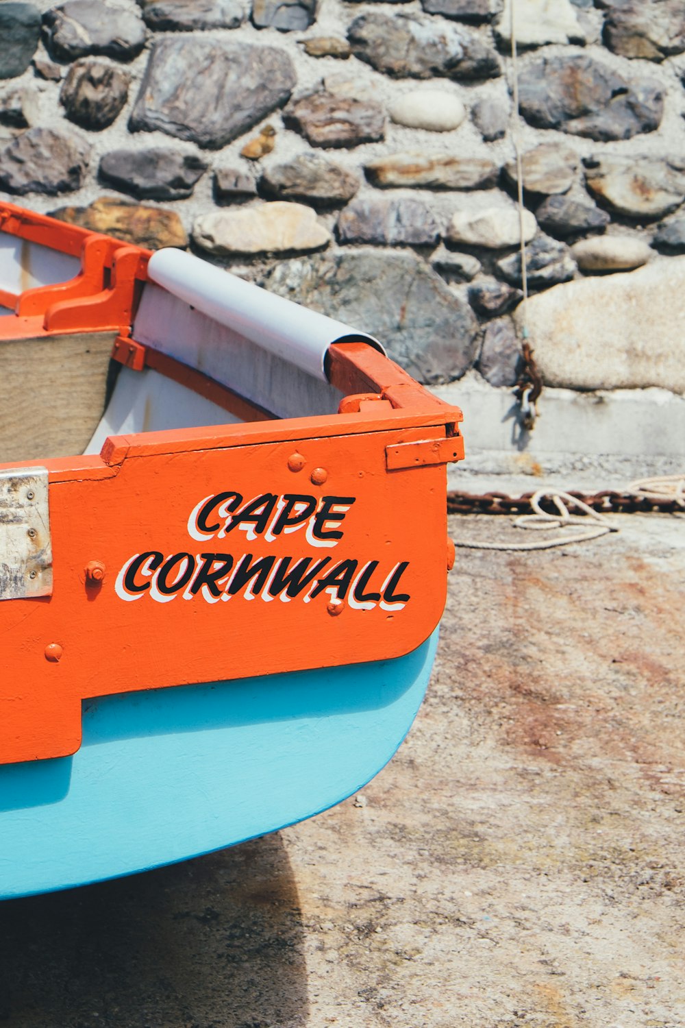 red and teal Cape Cornwall rack near stone wall