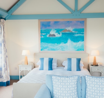 white and blue pillows beside brown table lamp