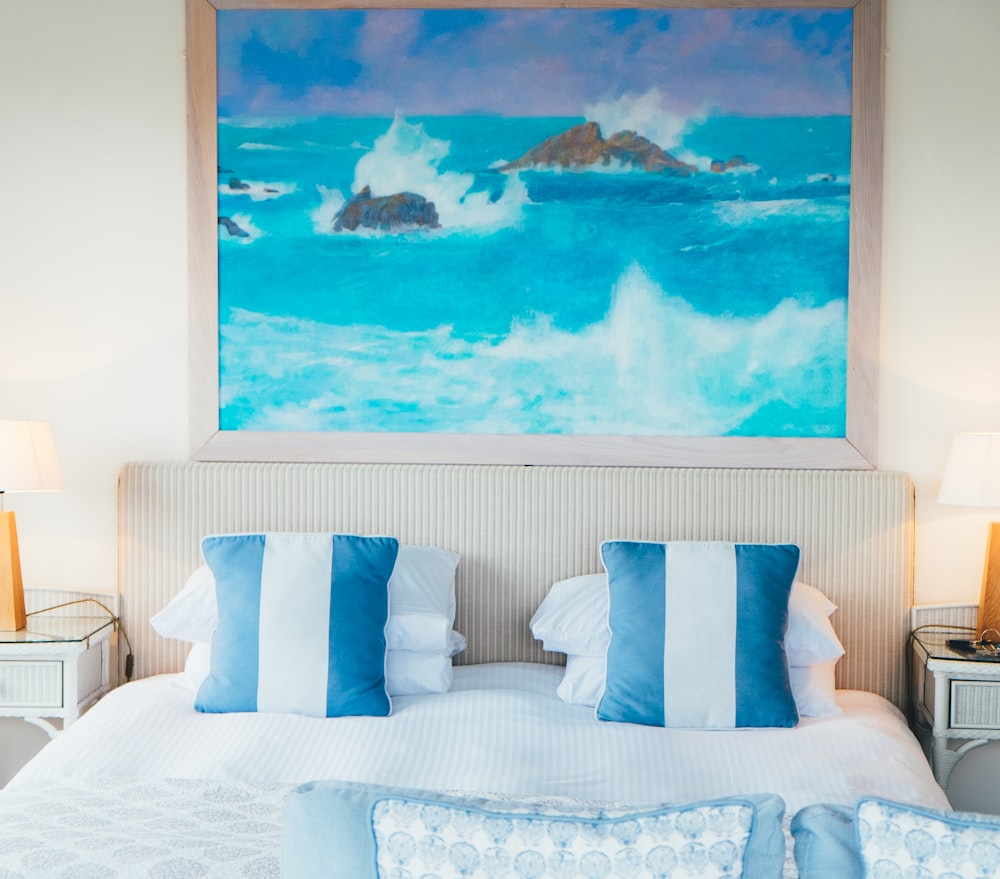 ocean with rocks painting on wall near bed