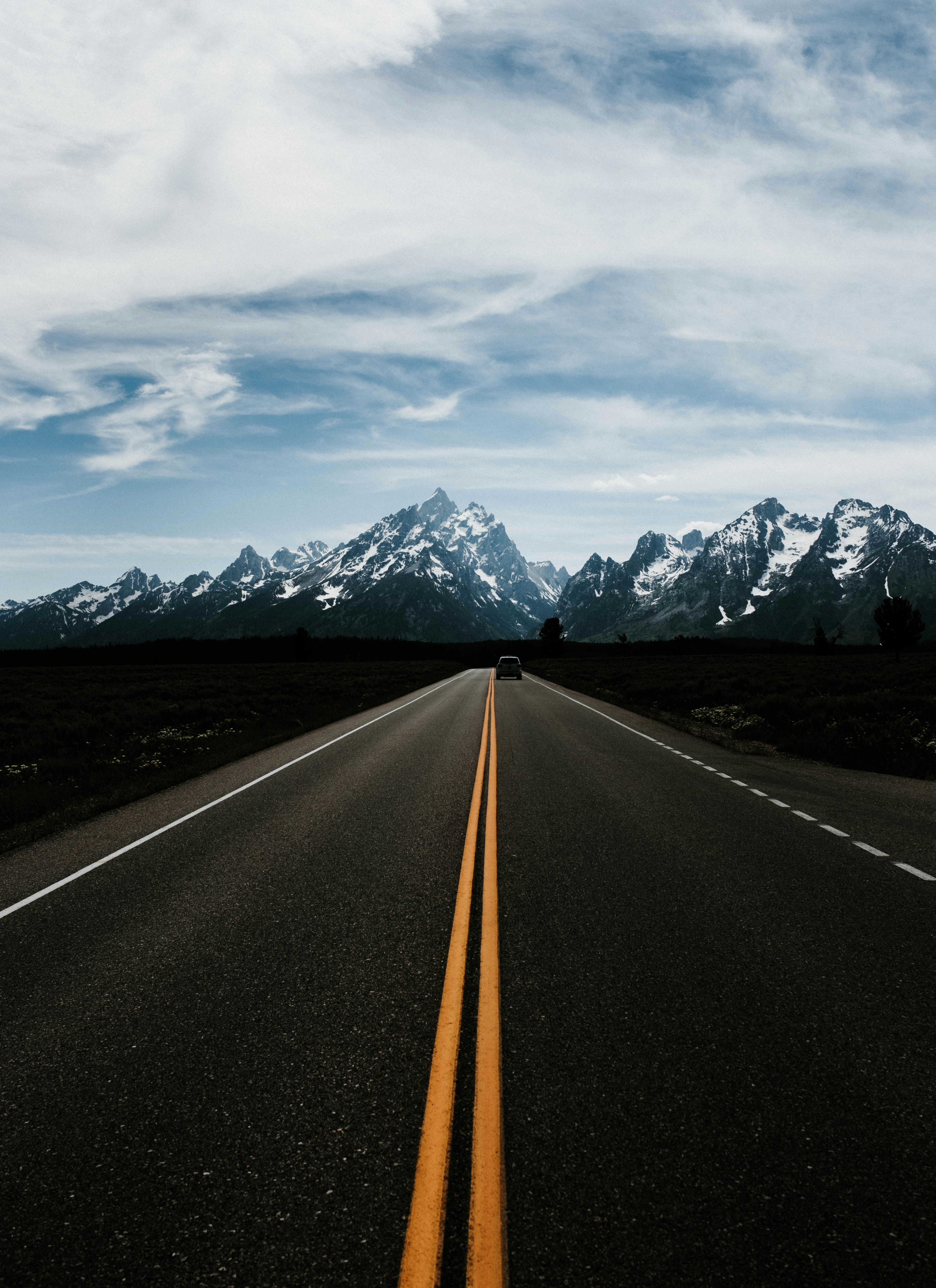 Vehicle on straight countryside road leading to a mountain under ...