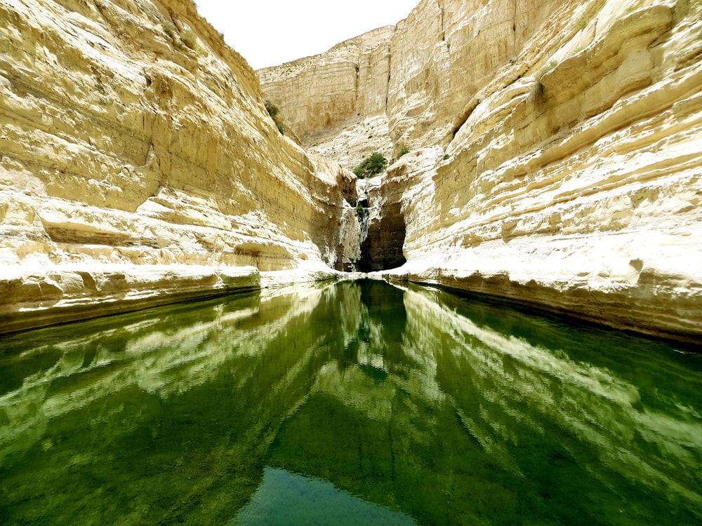 river surrounded by yellow rock formation