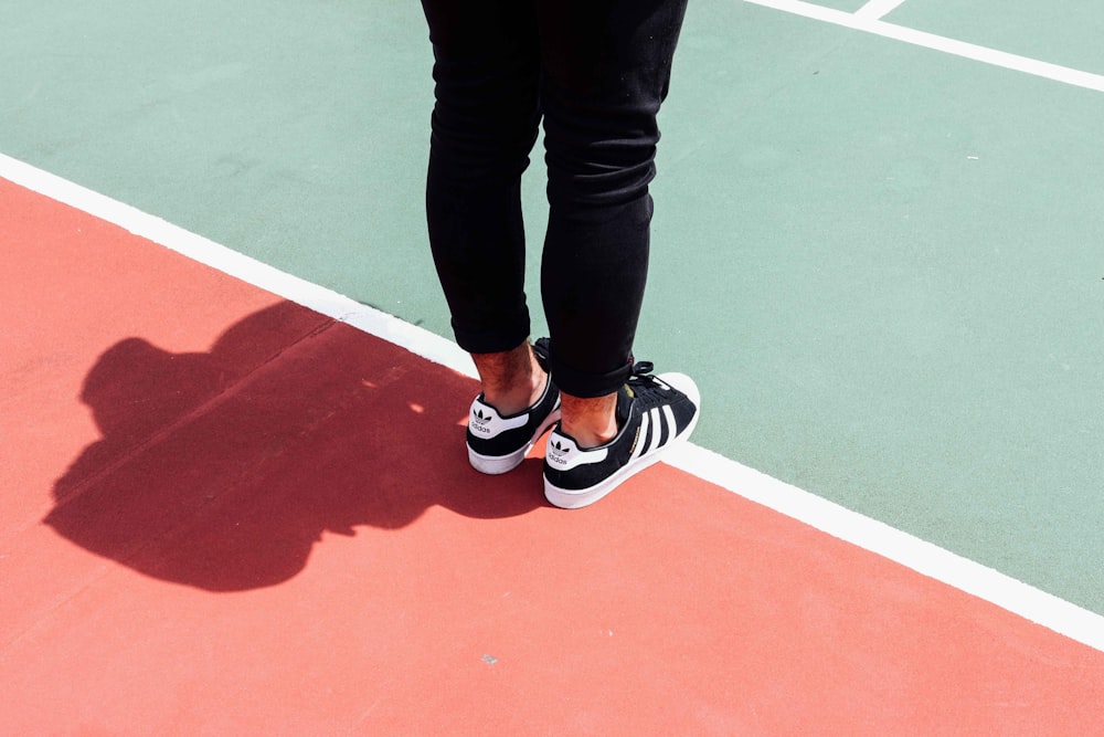 person wearing black adidas sneakers photo – Free Wellness Image on Unsplash
