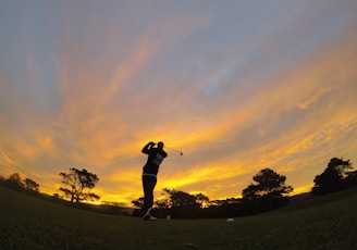 silhouette of man holding golf club