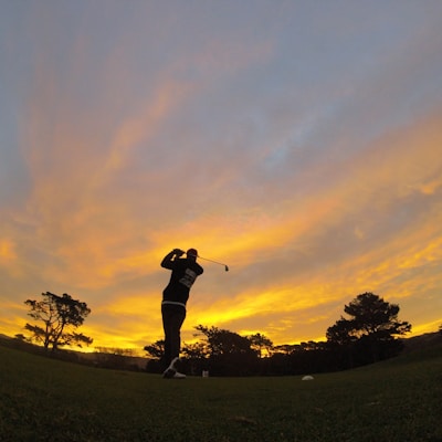 silhouette of man holding golf club