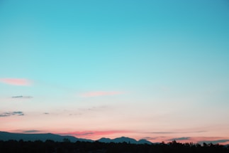 A serene landscape with a colorful sunset over rolling hills.