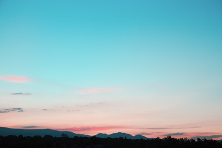 A serene landscape with soft rolling hills and a calming sunset in the background.