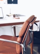 closeup photography of brown leather chair near white table