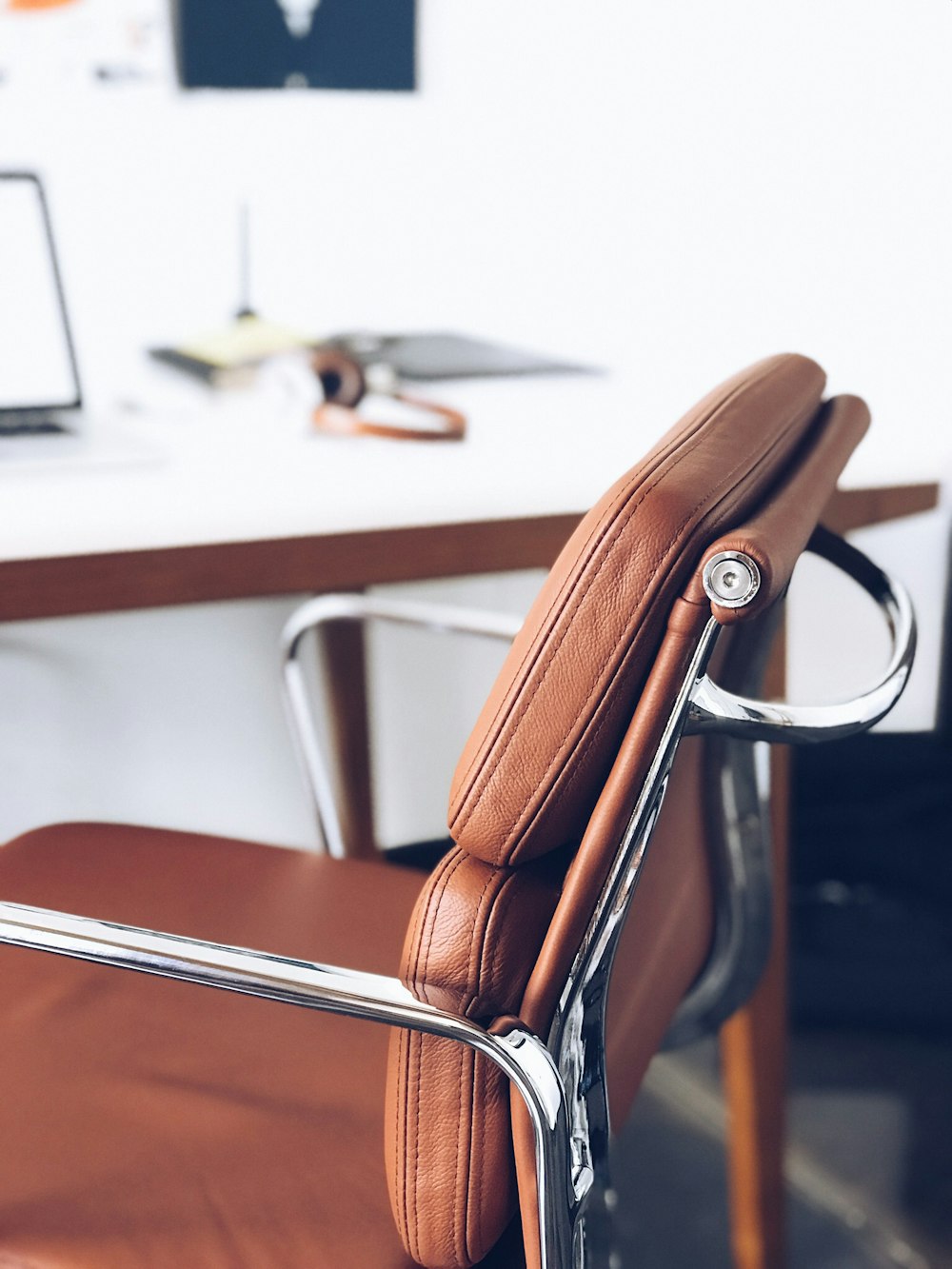 closeup photography of brown leather chair near white table