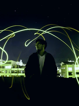 A mysterious figure silhouetted against a glowing gold-lit rooftop party.