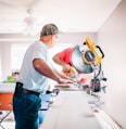 man standing infront of miter saw