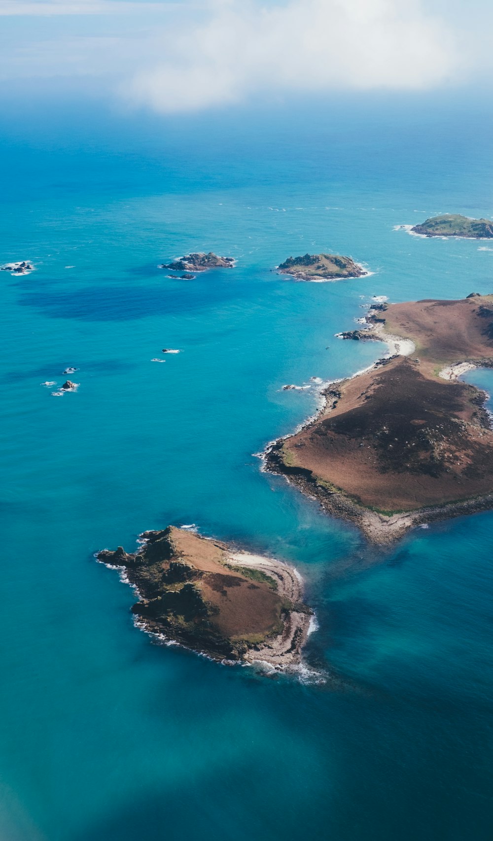 Braune Insel, die tagsüber von blauem Gewässer umgeben ist