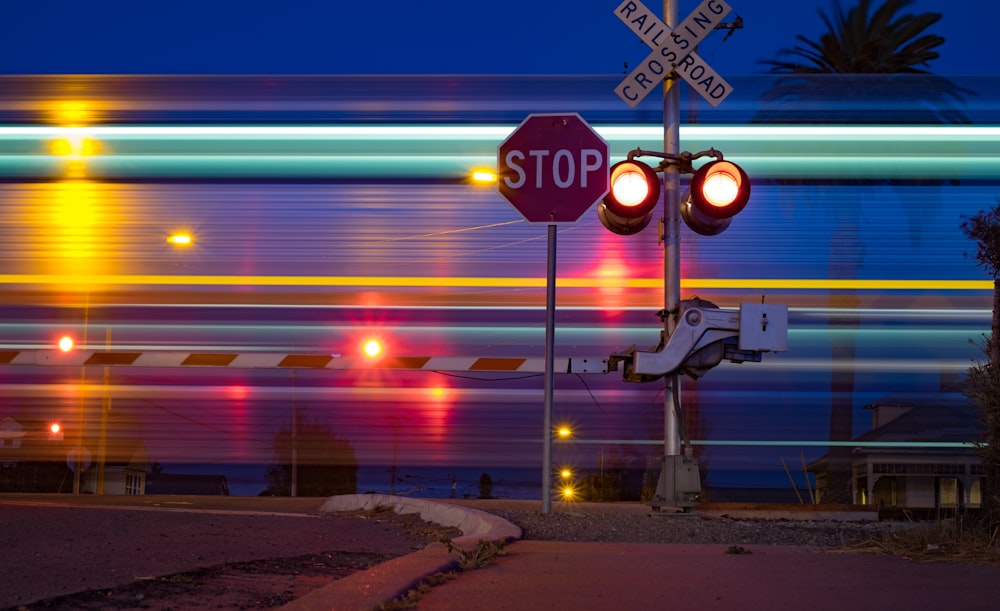 stop signage beside crossing railroad road sign at nighttime