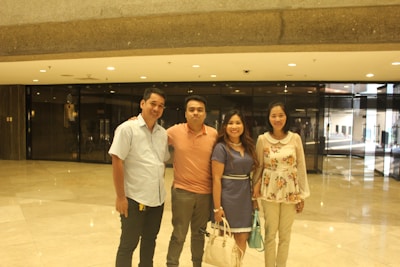A vibrant team photo of the four co-founders of Impulse Property Group standing in front of a newly renovated eco-friendly home.