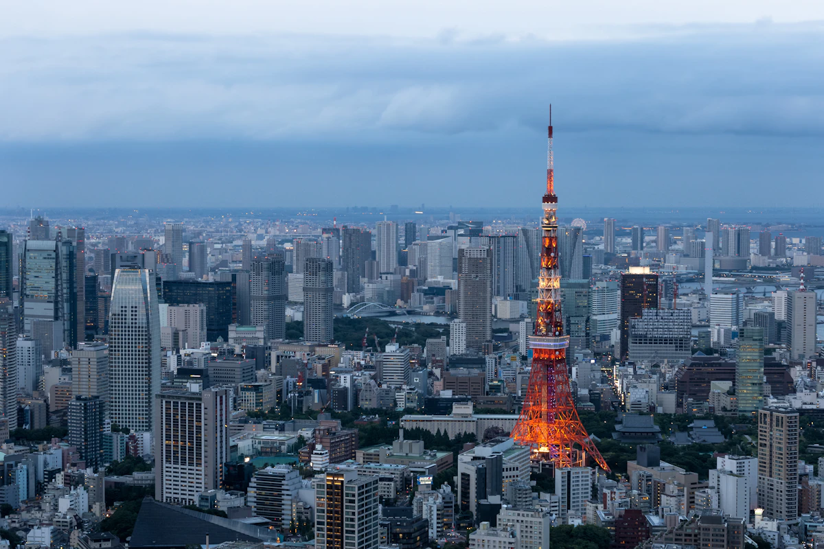 Tokyo Tower illuminated at dusk above the Minato cityscape