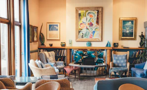 A warm, inviting living room in a residential care home with soft blue and purple accents.