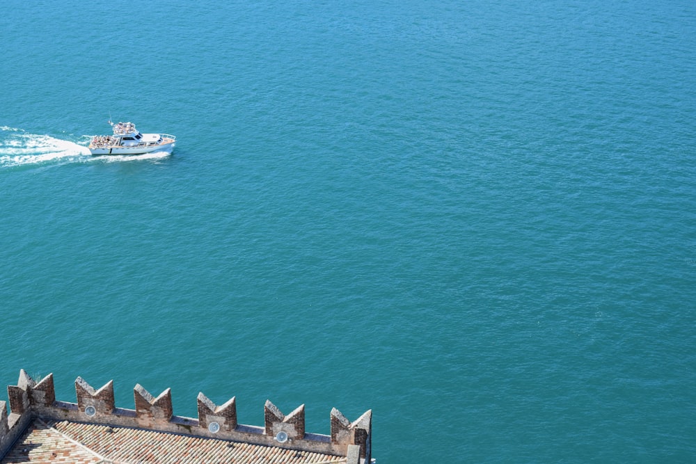 Bateau à moteur blanc naviguant sur l’océan pendant la journée