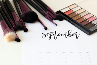 An elegant makeup brush set arranged neatly beside a calendar with booking notes.