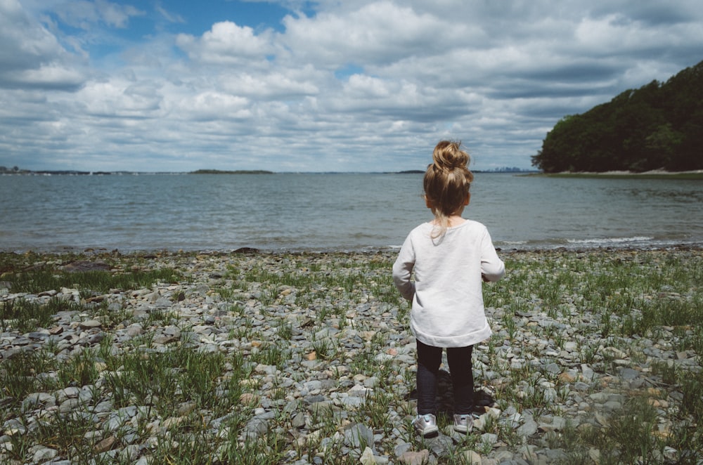 昼間の海岸に立つ少女