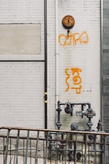 grey steel water pipe near wall